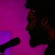 Silhouette closeup of Tongo Eisen-Martin speaking into mic.