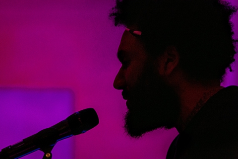 Silhouette closeup of Tongo Eisen-Martin speaking into mic.